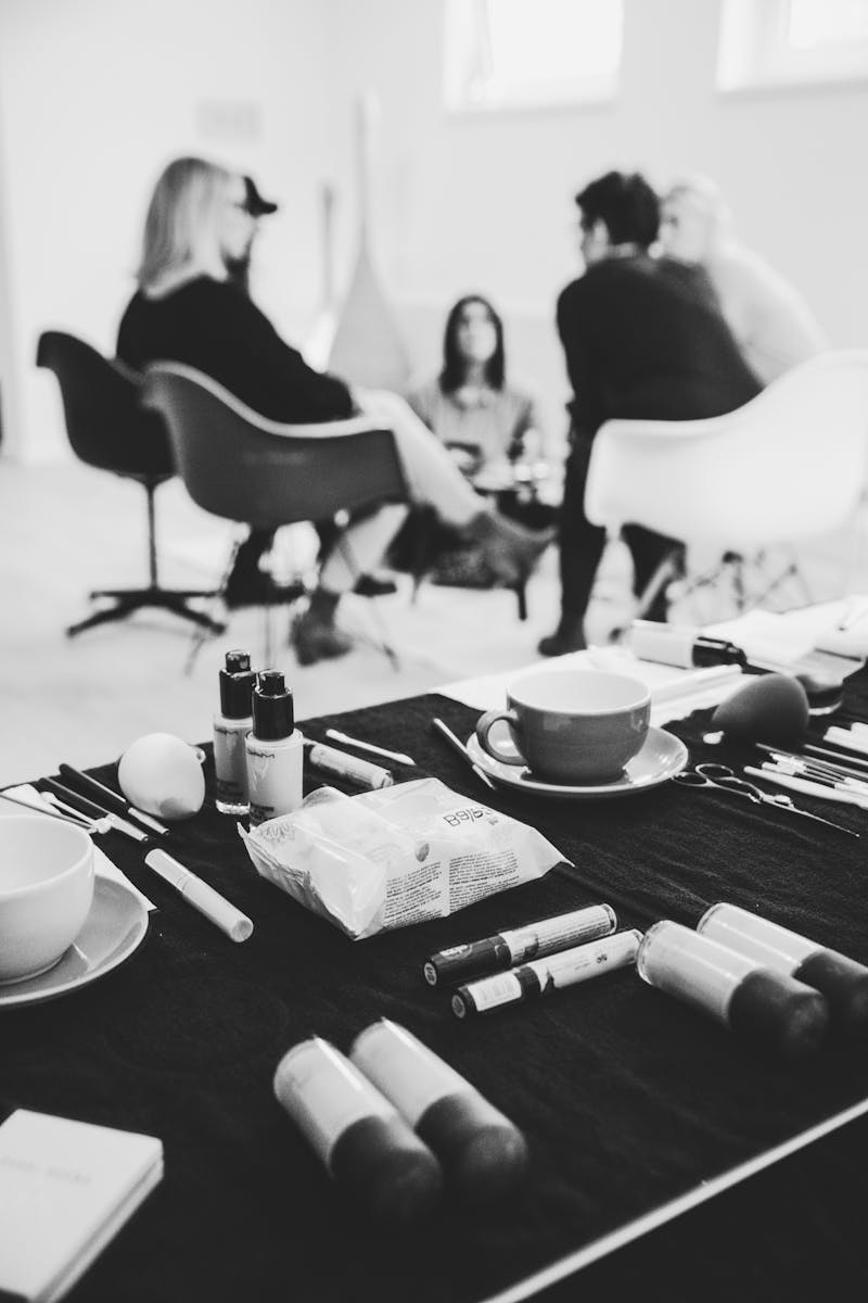 Grayscale Photography of People Sitting on Chair